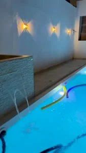 Piscina iluminada e cascata do Recanto Oásis à noite
